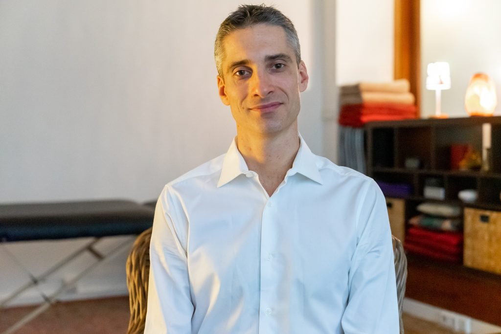 Xavier Foucher souriant dans son cabinet de massage à Paris